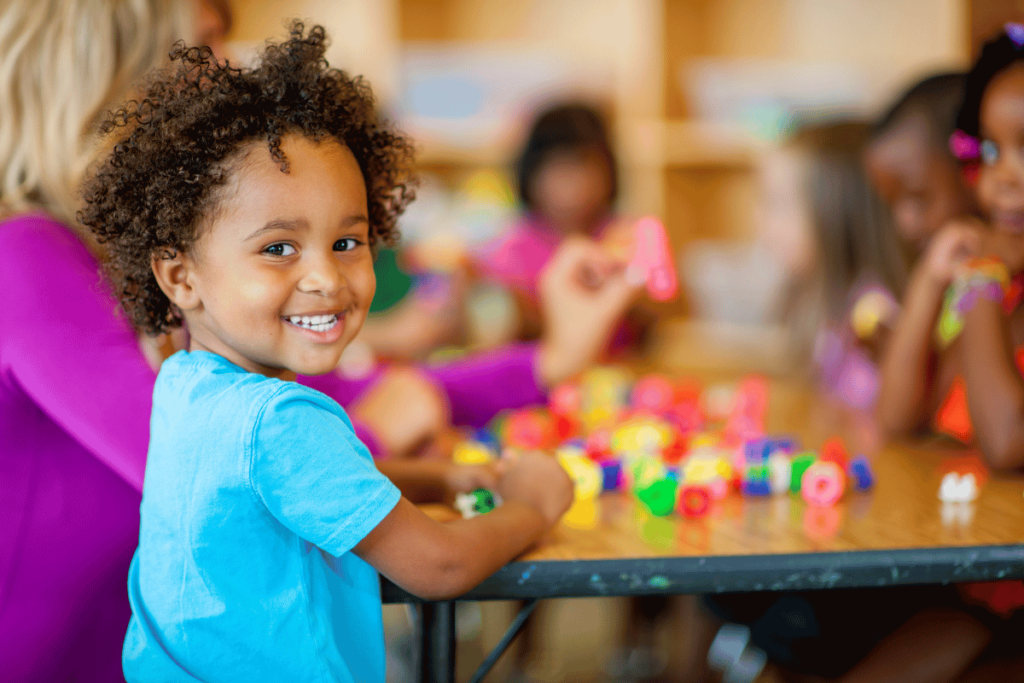 little kid smiling and playing with toys