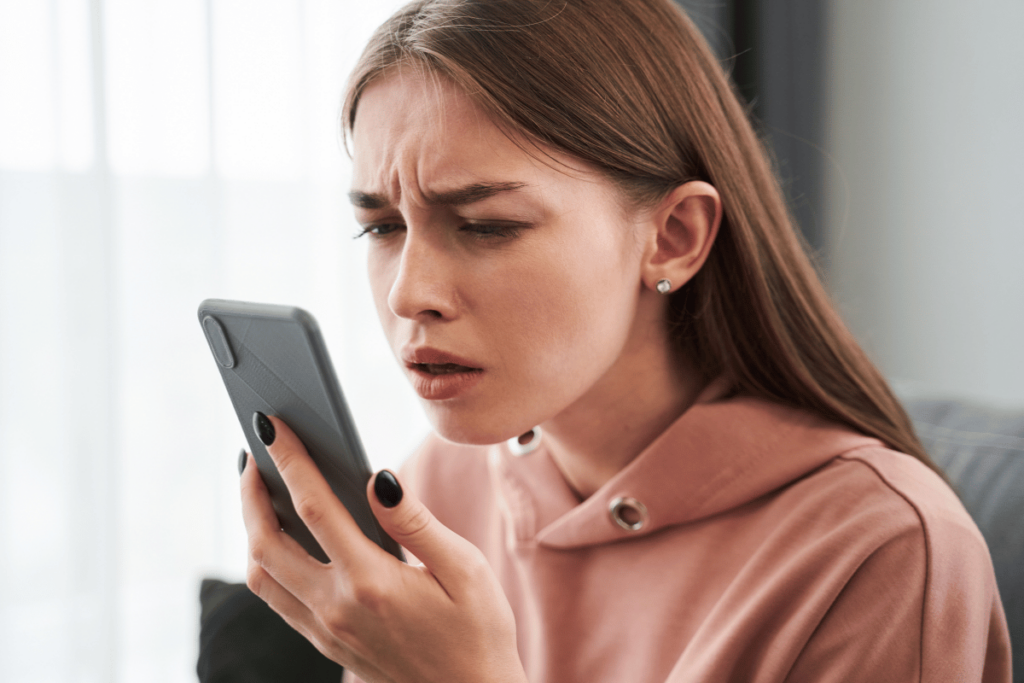 a young woman having trouble seeing her phone