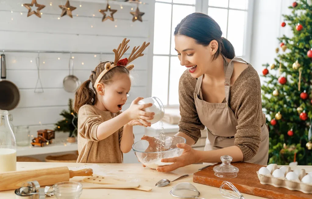 holiday-vision a mom and her young daughter baking cookies at home